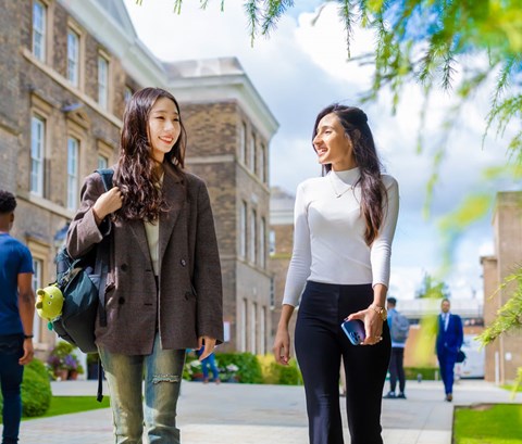 Students walking past the Fielding Johnson Building on a sunny day